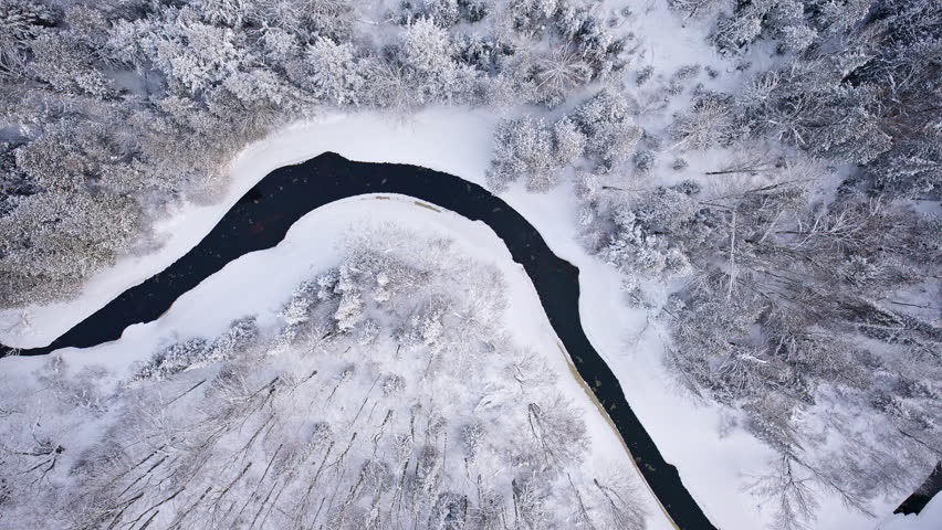 Snow-covered river corridor captured during winter in Northern Michigan.