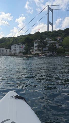 Boat trip view of Fatih Sultan Mehmet Bridge and Anadolu Hisari coastline on the Bosphorus in Beykoz Istanbul with calm water and green hills