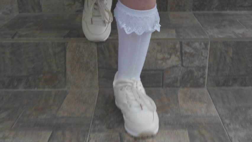 A girl in a purple dress walks down the stairs close-up, A child