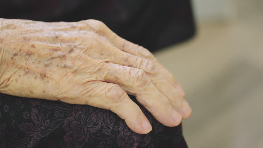 Slow motion Close Up of Young Hand Holding Elderly Hand for Comfort and Support.