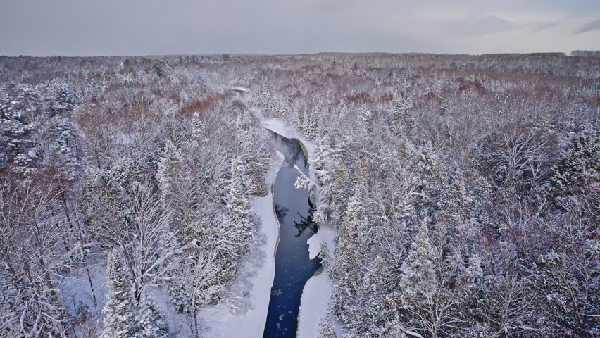 Winter landscape highlighting a winding river beneath a blanket of snow.