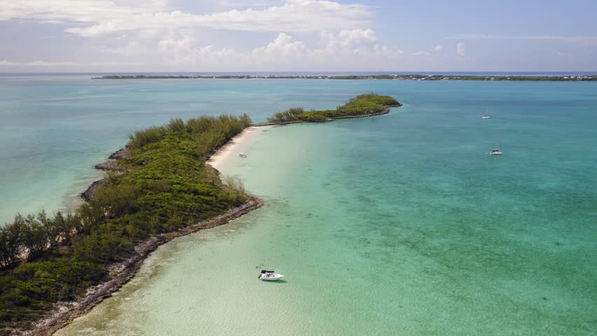 Aerial view of the coastal landscape of Spanish Wells with turquoise waters, a small island, and a boat in Spanish Wells, Spanish Wells, The Bahamas.