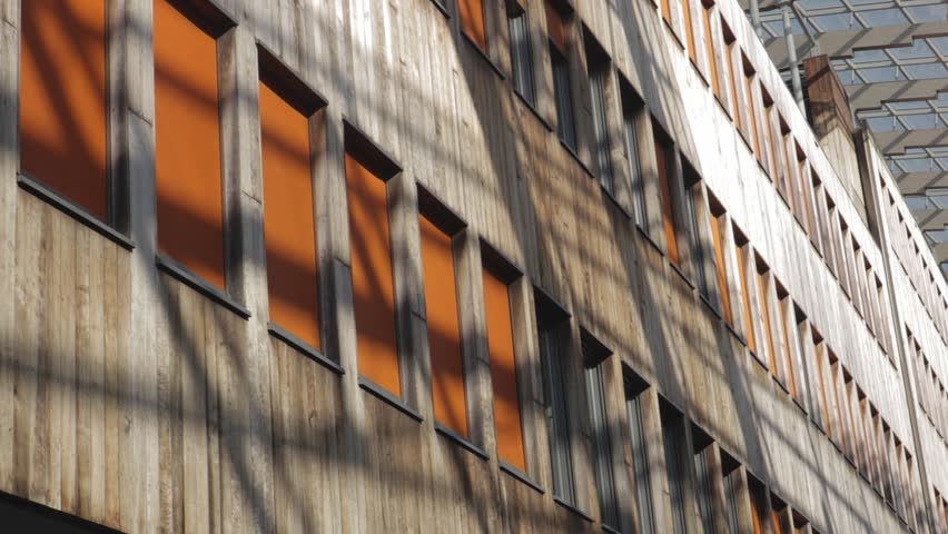Modern wooden building facade with orange windows in Aker Brygge Oslo