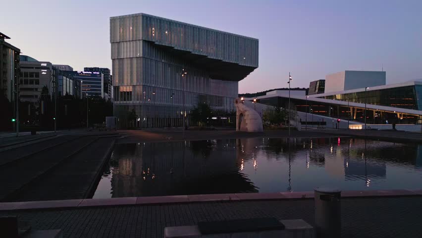 Aerial view of the Munch Museum and the Oslo Opera House at dusk with a reflecting pool in the foreground in Oslo, Oslo, Norway.