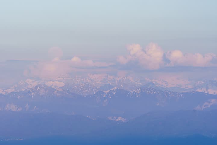 Majestic full moon ascending over the scenic Dents du Midi mountain range during a colorful twilight