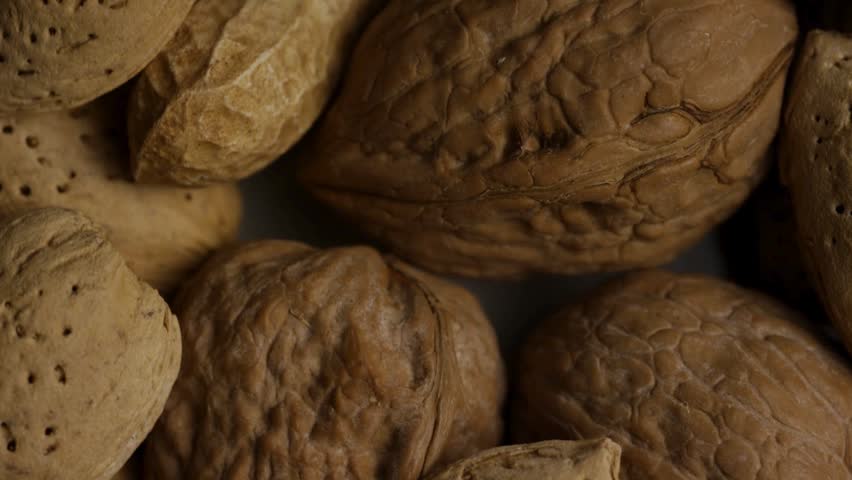 Macro close up view of mixed nuts including walnuts almonds and peanuts in shells textured background healthy snack assortment organic food