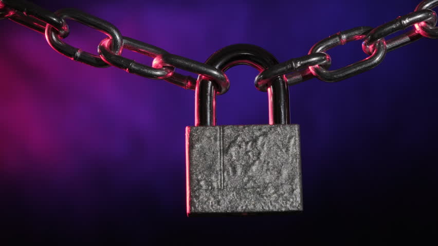 Locked padlock swinging on chain with flashing light from police flasher on black background, concept of detention, arrest