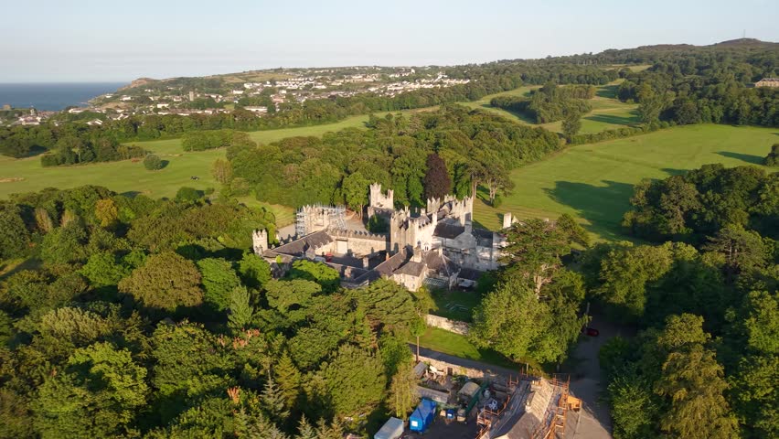 Epic aerial of Howth Castle glowing in golden sunset light, County Dublin, Ireland