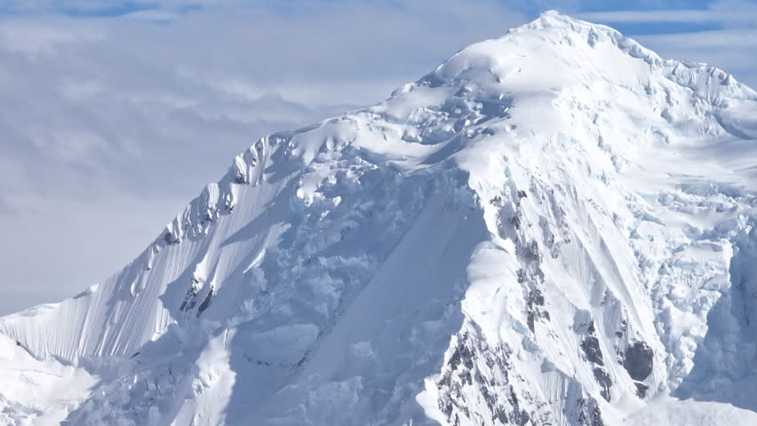 Snow covered mountain peak with steep icy slopes