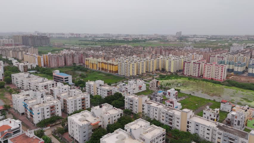 Apartment blocks surround a small pond as drone advances over Chennai