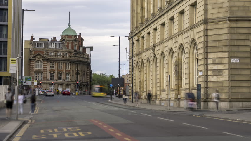Timelapse of Manchester city street with buses and pedestrians.