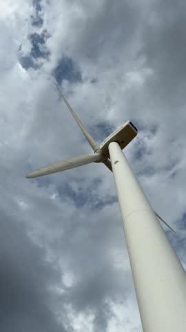 Windswept landscape under a bright sun with spinning turbines in a serene desert setting
