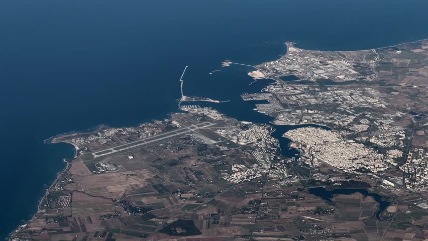 flying along Brindisi, a city in the region of Apulia in southern Italy, with Brindisi Papola Casale Airport, Cityscape and Brindisi Harbor, located at Adriatic Sea coastline - 4k aerial video footage