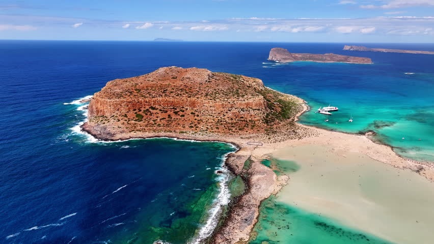 High angle drone photo of Balos beach lagoon with turquoise shallow water, white sand and peninsula in Crete, Greece on a bright sunny summer day.