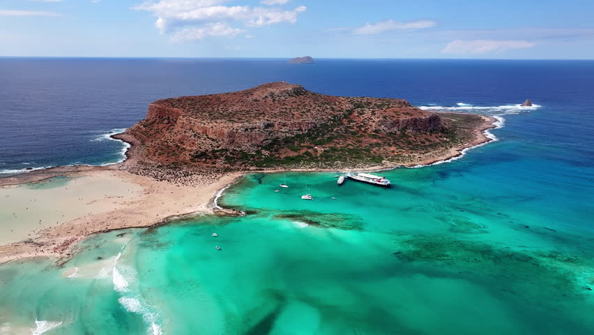 High angle drone photo of Balos beach lagoon with turquoise shallow water, white sand and peninsula in Crete, Greece on a bright sunny summer day.