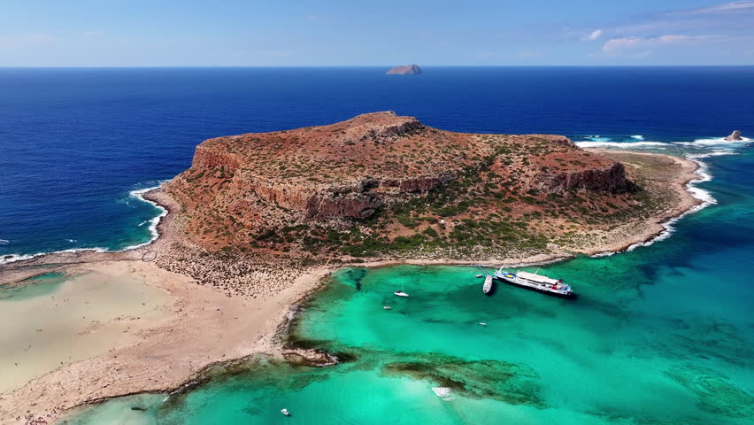 High angle drone photo of Balos beach lagoon with turquoise shallow water, white sand and peninsula in Crete, Greece on a bright sunny summer day.