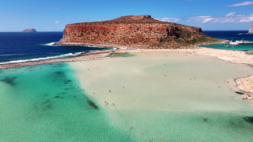 High angle drone photo of Balos beach lagoon with turquoise shallow water, white sand and peninsula in Crete, Greece on a bright sunny summer day.