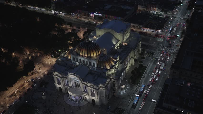 Illuminated palace of fine arts and city traffic at night in the historic center of mexico city