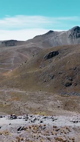 Nevado de Toluca crater lakes and Humboldt viewpoint, vertical pan left across rugged volcanic landscape near Toluca, Mexico