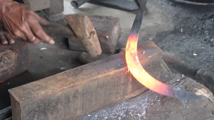 Blacksmith Forging Heated Metal on Anvil