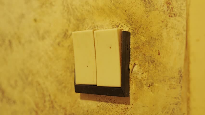 Aged double light switch on textured wall reflects timeless residential design.