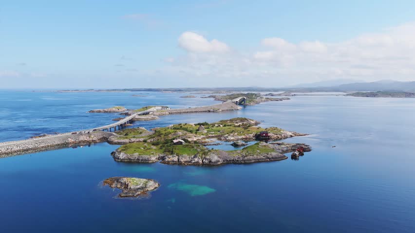 Aerial drone view of the Atlantic Ocean Road in Norway. Winding highway bridge connecting islands across rough ocean waves during a scenic coastal road trip.