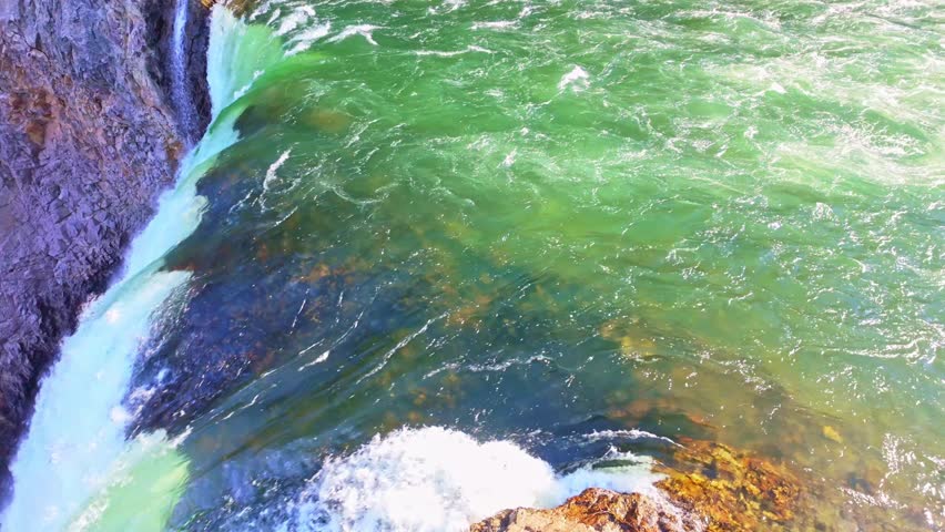 Upper Falls plunges into the Grand Canyon of the Yellowstone surrounded by rugged cliffs and evergreen forest