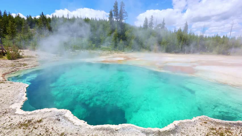 Steam rises above the crystal blue waters of Abyss Pool in Yellowstone National Park