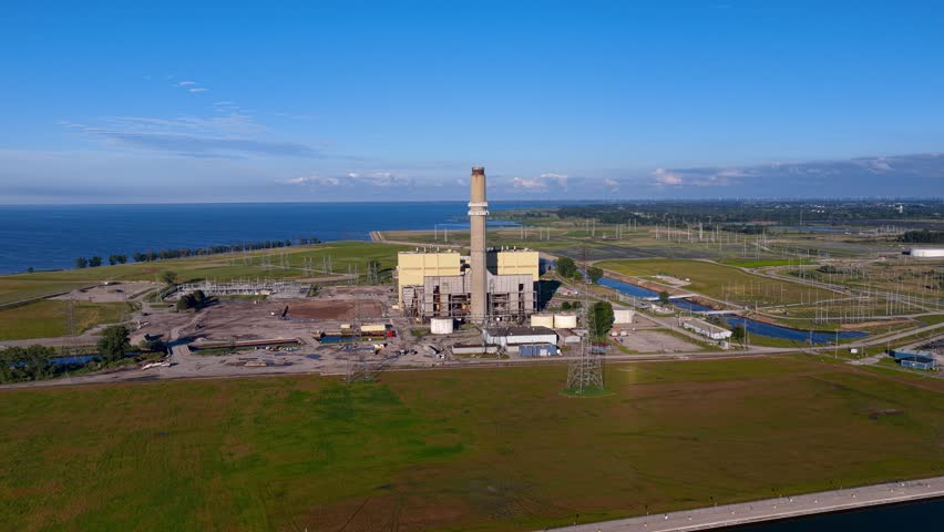 Industrial facility with a smokestack on the Hurun lake cost line in Michigan