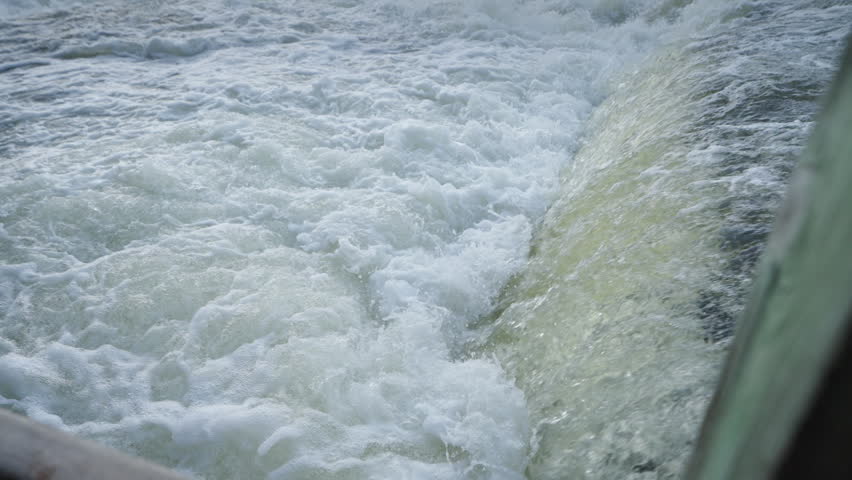 Turbulent white water cascades over a rocky shelf at Sauble Falls during the spring run. A close-up view captures the churning currents and thick foam of the rushing river.