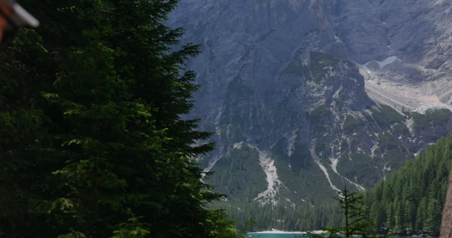A Hiker Carrying A Backpack Walks Along Mountain Trails Near Lago di Braies In The Dolomites of Italy. Slow Motion Shot