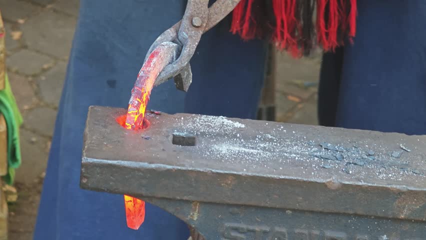 A horseshoe maker against a background.