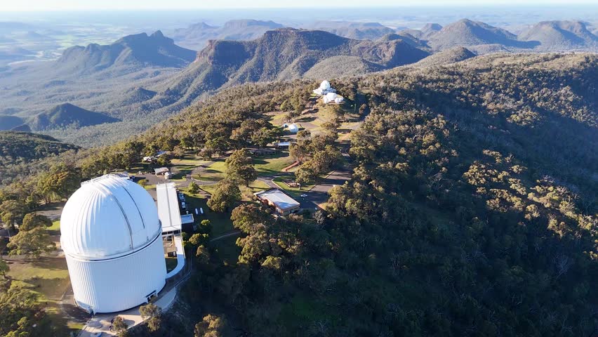 Drone shot of telescope domes on a mountain ridge in Warrumbungle National Park, Australia.