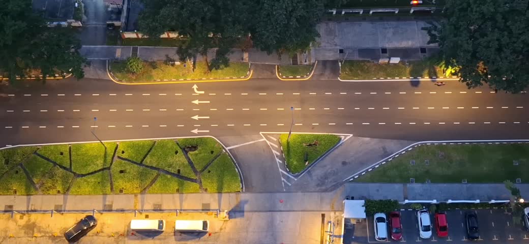 Aerial top-down view of light traffic moving along Jalan Macalister in George Town, Penang, Malaysia at dusk. The footage features illuminated roads, vehicles, road markings, and an urban cityscape, making it suitable for transportation, travel, infrastructure, and city lifestyle concepts.