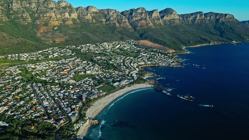 Camps Bay and Cape Town, South Africa, with Table Mountain rising above the Atlantic coastline, beaches and waterfront scenery, cinematic aerial view