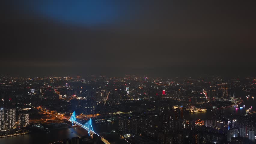 Aerial night view illuminated modern city skyline with skyscrapers buildings and river. Urban architecture, business center scenery night. Metropolitan landscape glowing lights. Twilight town travel.