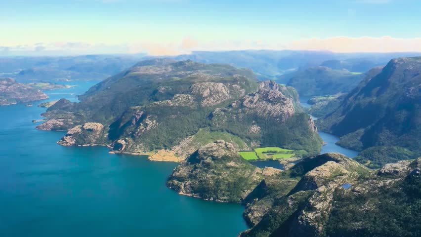 Scenic Aerial View of a Calm Lake Surrounded by Mountains Beneath a Foggy Sky