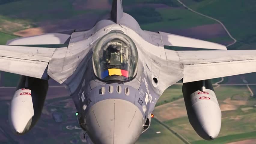 Close-up of a U.S. Air Force F-16 Fighting Falcon during high-speed tactical flight above rural countryside in daylight conditions.