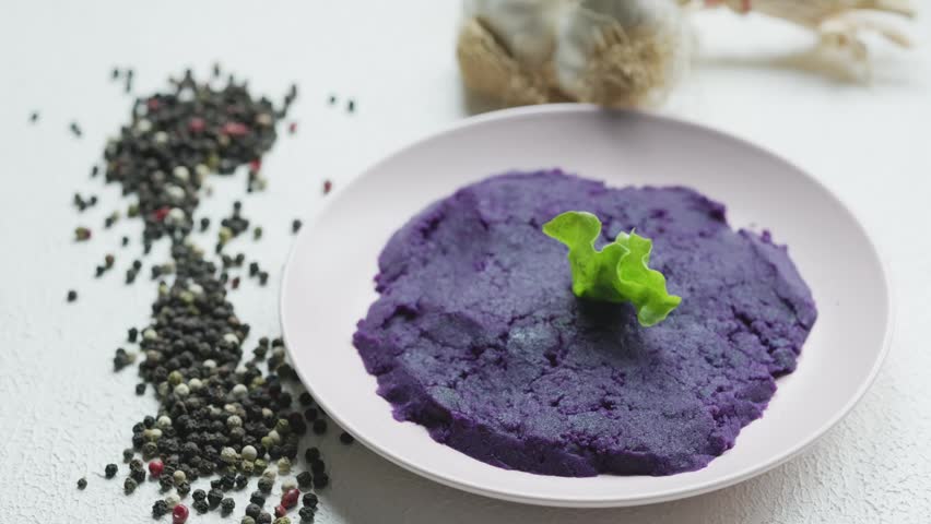 Close-up of vibrant purple mashed potatoes served in a rustic bowl