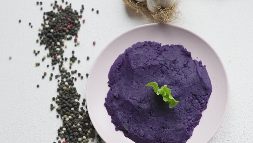 Close-up of vibrant purple mashed potatoes served in a rustic bowl