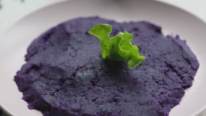 Close-up of vibrant purple mashed potatoes served in a rustic bowl
