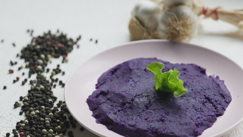 Close-up of vibrant purple mashed potatoes served in a rustic bowl