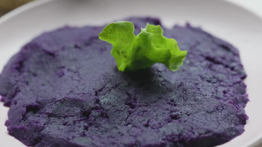 Close-up of vibrant purple mashed potatoes served in a rustic bowl