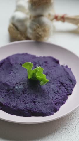 Close-up of vibrant purple mashed potatoes served in a rustic bowl
