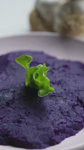 Close-up of vibrant purple mashed potatoes served in a rustic bowl