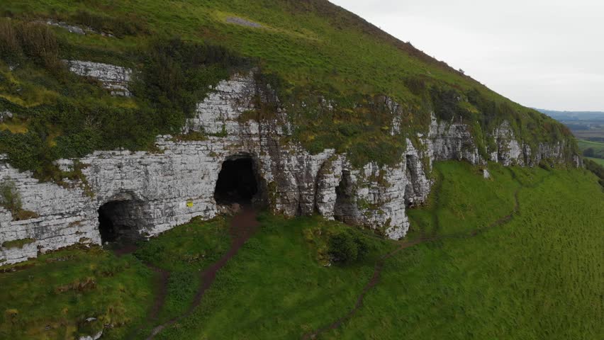 Cinematic aerial drone flight revealing the ancient Keash Caves on the limestone cliffs of Keshcorran Hill in County Sligo, West of Ireland. Captures the rugged beauty of the Irish landscape.