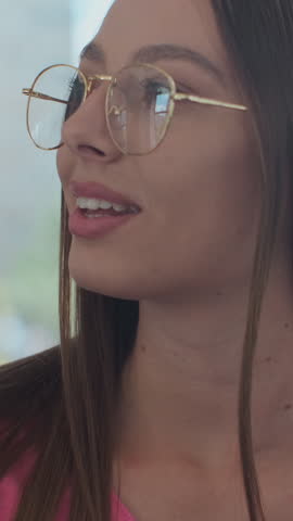 Vertical video. Young stylish woman dressed brightly enjoying trip at the public transport, sitting in the modern tram.