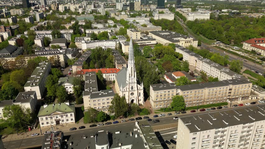 Cinematic drone shot of Warsaw’s Evangelical Reformed Church, capturing its pointed tower, historic details and contrast with modern city buildings.