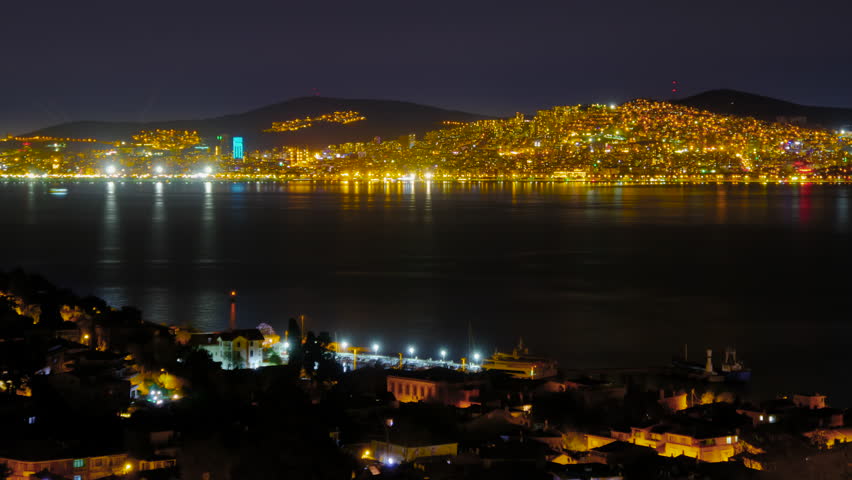 Timelapse: illuminated ferries are crossing the Marmara Sea from Princes Islands as Istanbul city lights shine across the water. Night reflections and harbor lights - time lapse