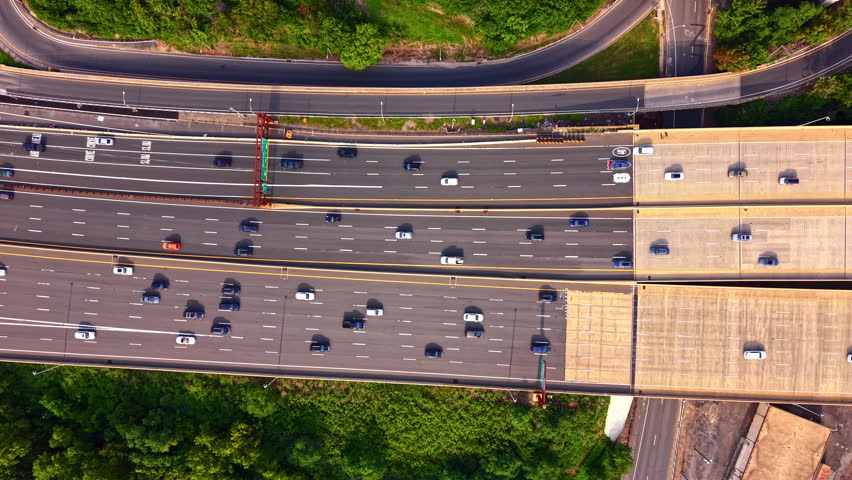 Elevated view of highway curve with route signage, New Jersey. Drone shot of multilane traffic, curve ahead sign and interstate route marker overhead. Garden state parkway